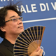 Bong Joon Ho holds a fan on the red carpet.
